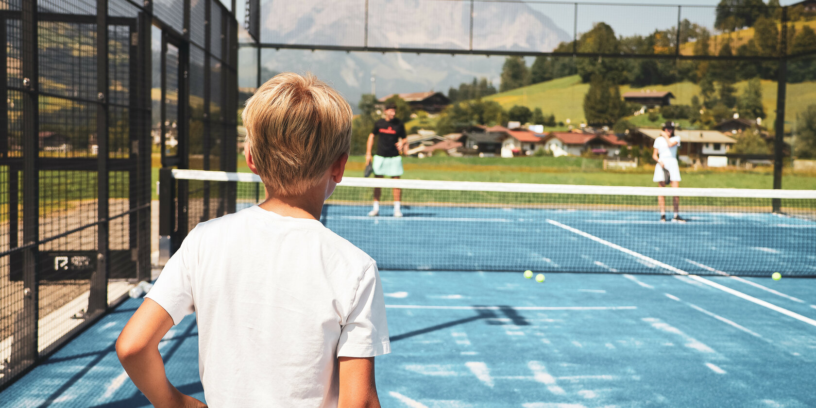Ein weißer Flurbereich mit einer offenen Garderobe, Kissen und einem kleinen schwarzen Schild
