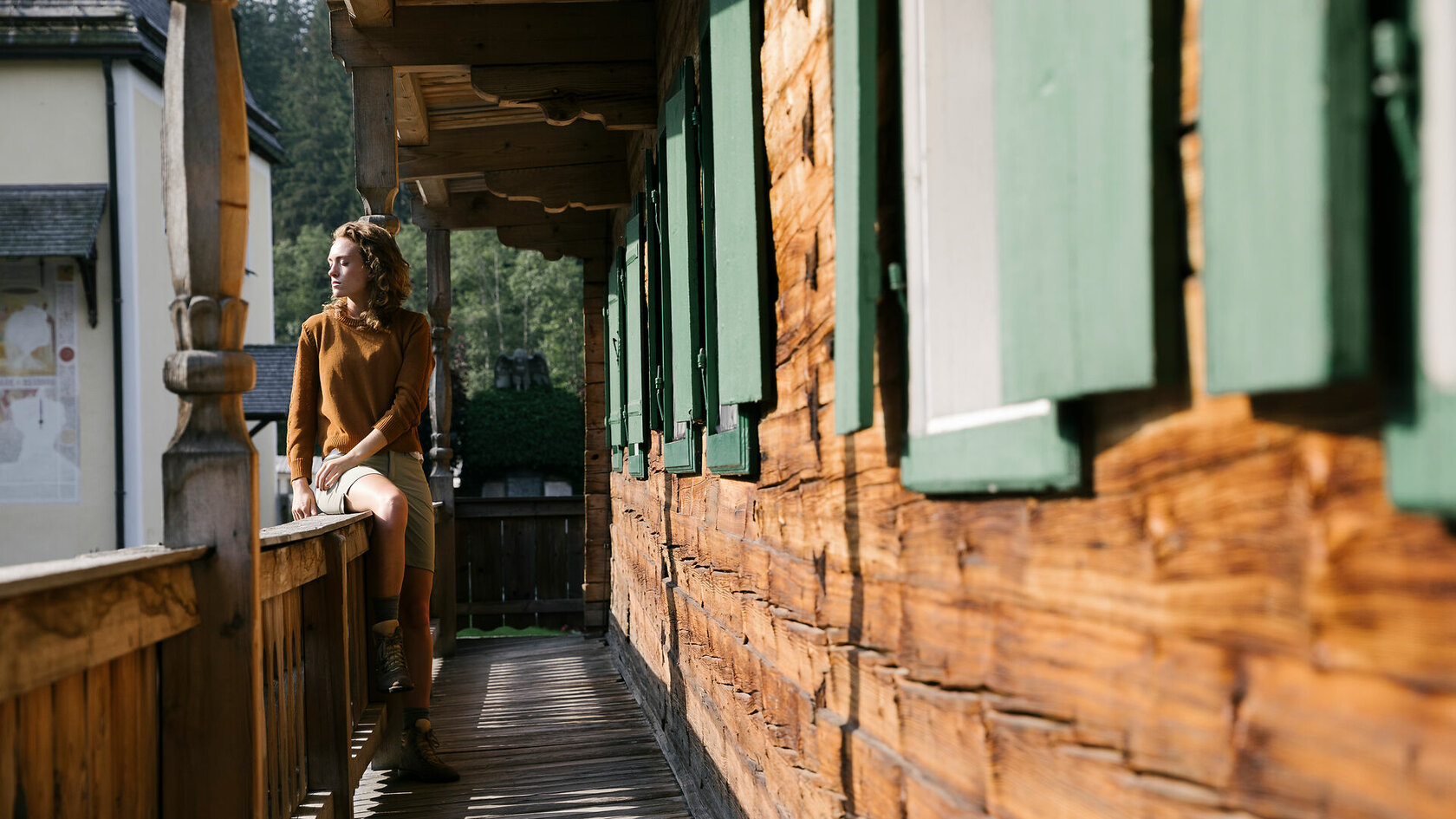 Ein weißer Flurbereich mit einer offenen Garderobe, Kissen und einem kleinen schwarzen Schild