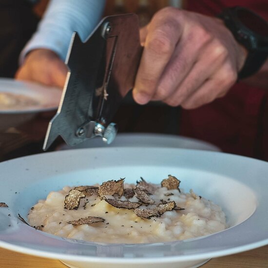 Ein weißer Flurbereich mit einer offenen Garderobe, Kissen und einem kleinen schwarzen Schild