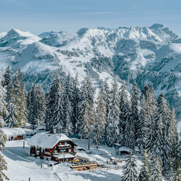 Sonnbühel, Skigebiet Kitzbühel – Gemütliche Berghütte in einer verschneiten Berglandschaft mit Tannenbäumen.