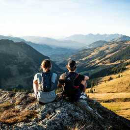 Zwei Personen mit Blick auf das Bergpanorama