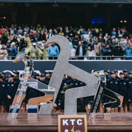Ein weißer Flurbereich mit einer offenen Garderobe, Kissen und einem kleinen schwarzen Schild