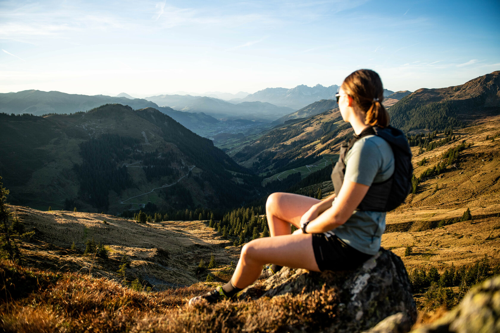 Ein weißer Flurbereich mit einer offenen Garderobe, Kissen und einem kleinen schwarzen Schild