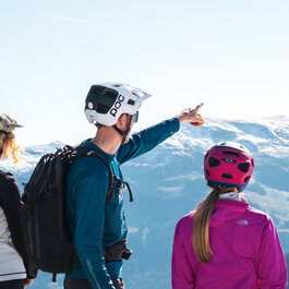 Ein weißer Flurbereich mit einer offenen Garderobe, Kissen und einem kleinen schwarzen Schild