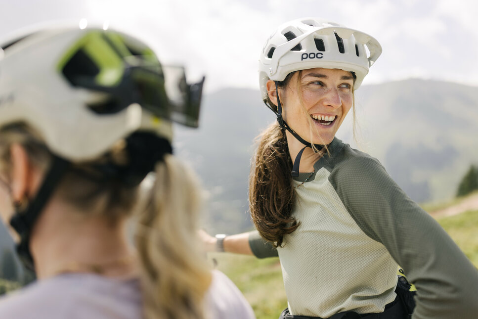 Ein weißer Flurbereich mit einer offenen Garderobe, Kissen und einem kleinen schwarzen Schild
