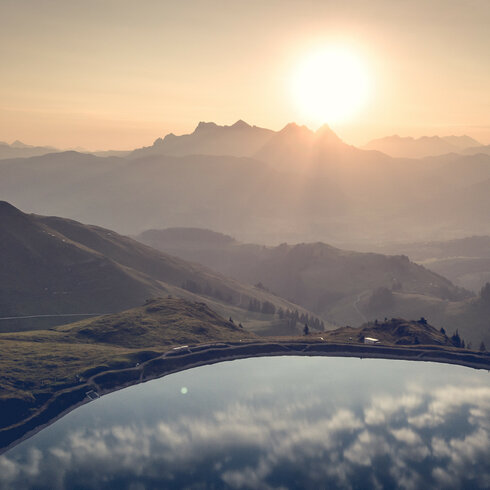 Ein weißer Flurbereich mit einer offenen Garderobe, Kissen und einem kleinen schwarzen Schild