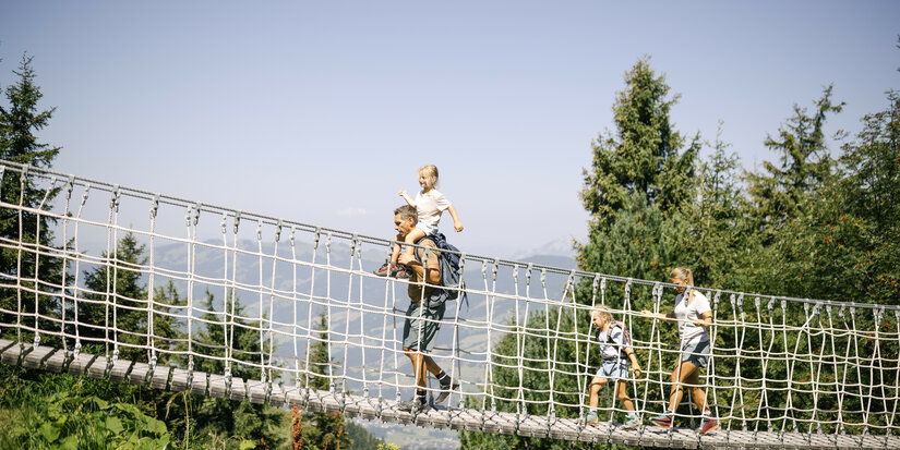 Kind läuft über Seilbrücke