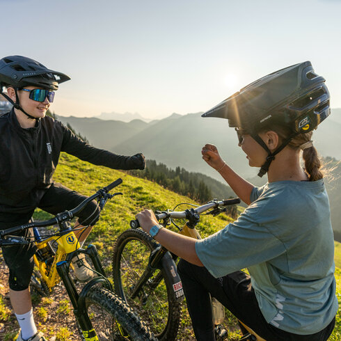 Ein weißer Flurbereich mit einer offenen Garderobe, Kissen und einem kleinen schwarzen Schild