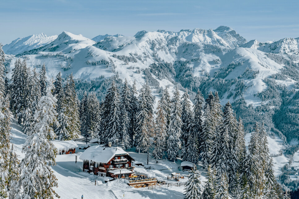 Sonnbühel Berggasthof, Skigebiet Kitzbühel, Berghütte in verschneiter Landschaft mit Tannenbäumen.
