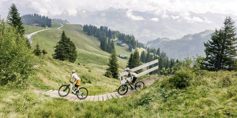 Ein weißer Flurbereich mit einer offenen Garderobe, Kissen und einem kleinen schwarzen Schild